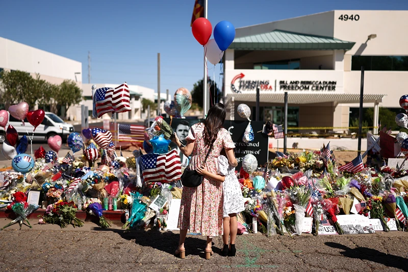 People gather at a makeshift memorial for political activist and Turning Point USA Founder Charlie Kirk outside of the Turning Point USA headquarters in Phoenix, Arizona, on September 14, 2025. The widow of prominent right-wing activist Charlie Kirk pledged on September 12 to carry on her husband's work, after US authorities announced his alleged assassin had finally been captured. The 31-year-old Kirk was hit by a single bullet while addressing a large crowd at Utah Valley University in the town of Orem on September 10. (Photo by CHARLY TRIBALLEAU / AFP) (Photo by CHARLY TRIBALLEAU/AFP via Getty Images)