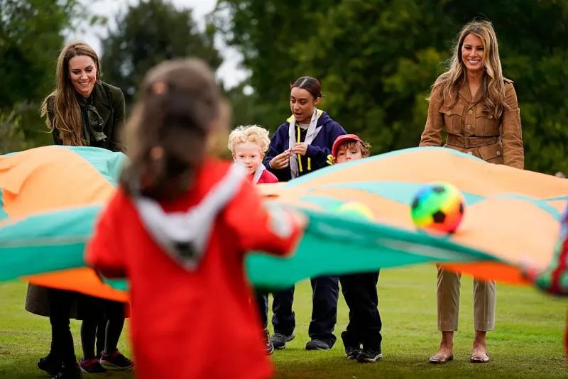 TOPSHOT - US First Lady Melania Trump (R) and Britain's Catherine, Princess of Wales (L) shake a parachute filled with balls with a group of Squirrels from the Scout Association at Frogmore Cottage on the Windsor Estate, in Windsor, on September 18, 2025, during the second State Visit of US President Donald Trump. US President Donald Trump and his wife Melania were treated to a sumptuous royal state banquet in Windsor Castle Wednesday, rounding off the US president's first full day of a historic second state visit to Britain. (Photo by Nathan Howard / POOL / AFP) (Photo by NATHAN HOWARD/POOL/AFP via Getty Images)