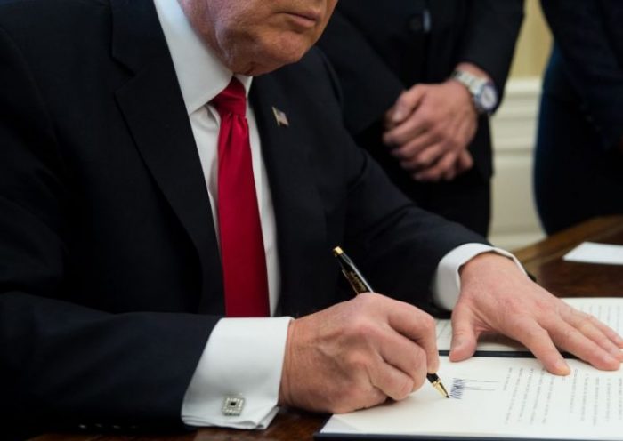 US President Donald Trump signs an executive order with small business leaders in the Oval Office at the White House in Washington, DC on January 30, 2017. / AFP PHOTO / NICHOLAS KAMM (Photo credit should read NICHOLAS KAMM/AFP via Getty Images)