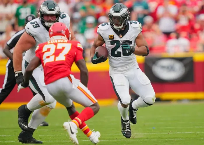 Philadelphia Eagles running back Saquon Barkley (26) carries the ball defended by Kansas City Chiefs safety Chamarri Conner (27) during the fourth quarter of the game at GEHA Field at Arrowhead Stadium. Mandatory Credit: Jay Biggerstaff-Imagn Images