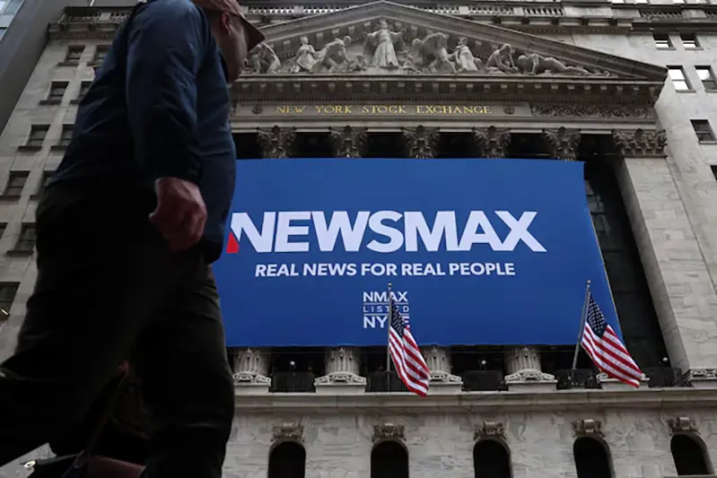 A banner for Newsmax Inc. is displayed during the company’s IPO at the New York Stock Exchange (NYSE) in New York City, U.S., March 31, 2025. REUTERS/Brendan McDermid/File Photo