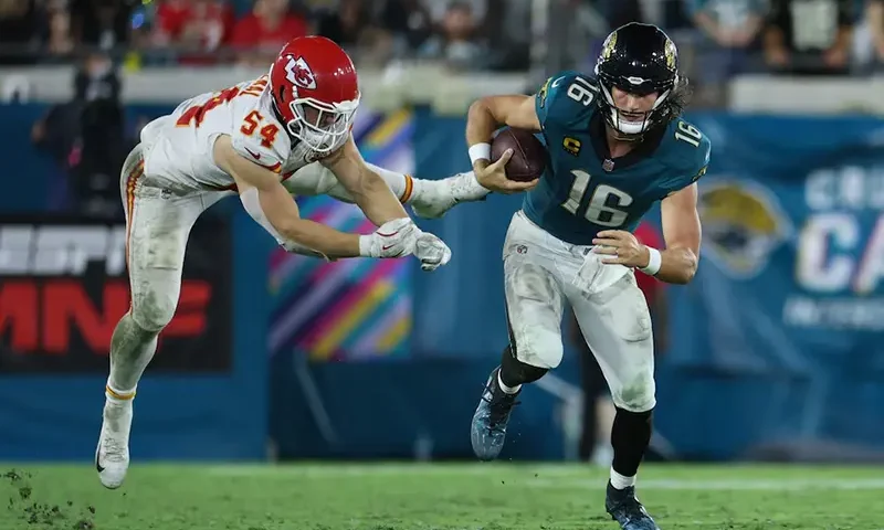 Jacksonville Jaguars quarterback Trevor Lawrence (16) runs against Kansas City Chiefs linebacker Leo Chenal (54) during the second half at EverBank Stadium. Mandatory Credit: Nathan Ray Seebeck-Imagn Images