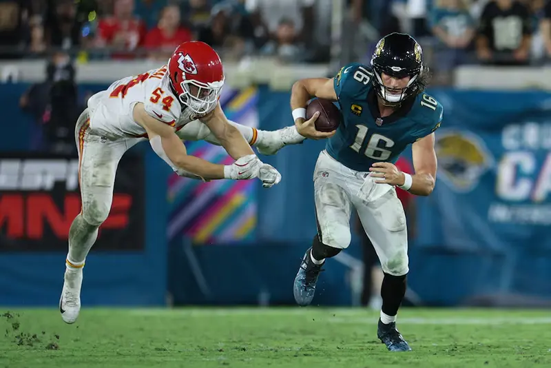 Jacksonville Jaguars quarterback Trevor Lawrence (16) runs against Kansas City Chiefs linebacker Leo Chenal (54) during the second half at EverBank Stadium. Mandatory Credit: Nathan Ray Seebeck-Imagn Images