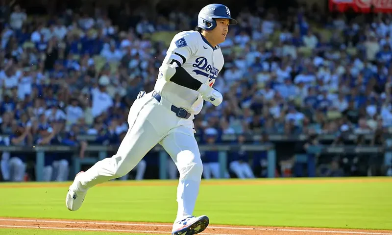 Los Angeles Dodgers two-way player Shohei Ohtani (17) runs after hitting a triple against the Milwaukee Brewers in the first inning during game three of the NLCS round for the 2025 MLB playoffs at Dodger Stadium. Mandatory Credit: Jayne Kamin-Oncea-Imagn Images