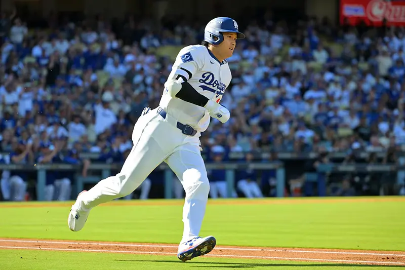 Los Angeles Dodgers two-way player Shohei Ohtani (17) runs after hitting a triple against the Milwaukee Brewers in the first inning during game three of the NLCS round for the 2025 MLB playoffs at Dodger Stadium. Mandatory Credit: Jayne Kamin-Oncea-Imagn Images