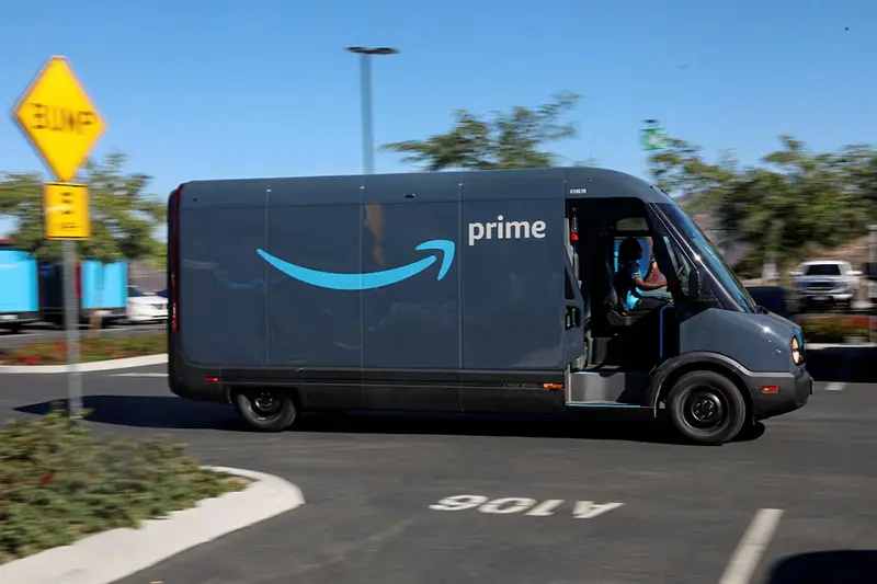 An electric Rivian truck purchased by Amazon is pictured working on delivery from the Amazon facility in Poway, California, U.S., November 16, 2022. REUTERS/Sandy Huffaker/File Photo