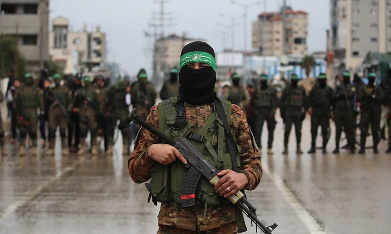 Hamas fighters gather at the site of the handing over of Israeli hostages at the Nuseirat refugee camp in the central Gaza Strip as part of the seventh hostage-prisoner release on February 22, 2025. Hamas's armed wing confirmed it will hand over on February 22 six hostages held alive in the Gaza Strip as part of the ongoing ceasefire deal with Israel. (Photo by Eyad BABA / AFP) (Photo by EYAD BABA/AFP via Getty Images)
