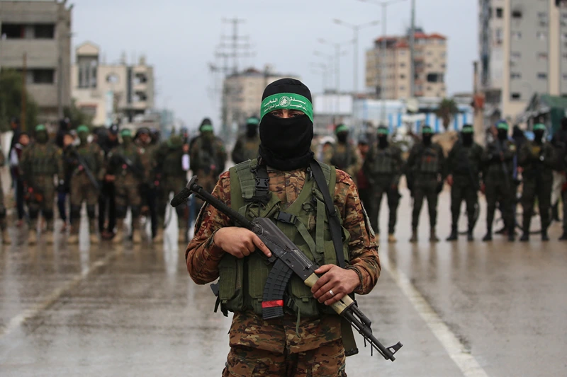 Hamas fighters gather at the site of the handing over of Israeli hostages at the Nuseirat refugee camp in the central Gaza Strip as part of the seventh hostage-prisoner release on February 22, 2025. Hamas's armed wing confirmed it will hand over on February 22 six hostages held alive in the Gaza Strip as part of the ongoing ceasefire deal with Israel. (Photo by Eyad BABA / AFP) (Photo by EYAD BABA/AFP via Getty Images)