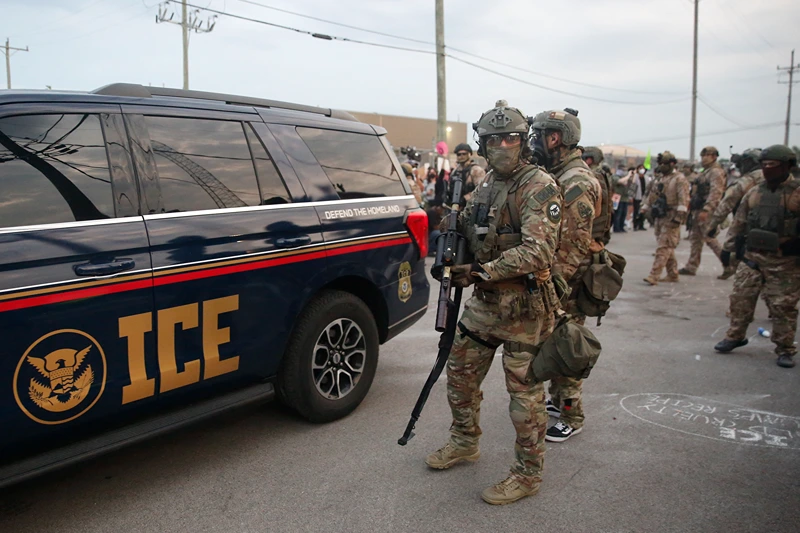 Immigration and Customs Enforcement (ICE) agents armed with less-lethal weapons gather outside an ICE processing center during a protest in Broadview, Illinois, on September 19, 2025. US President Donald Trump ordered increased federal law enforcement presence in Illinois and stepped-up immigration enforcement actions by the Department of Homeland Security. (Photo by OCTAVIO JONES / AFP) (Photo by OCTAVIO JONES/AFP via Getty Images)