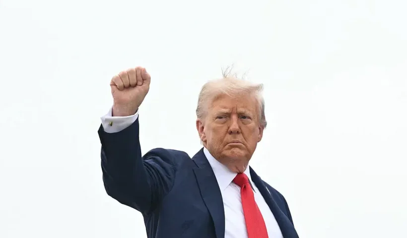 US President Donald Trump raises a fist as he makes his way to board Air Force One before departing from Joint Base Andrews in Maryland on September 21, 2025. Trump is heading to Glendale, Arizona to attend the public memorial service for Charlie Kirk. (Photo by Mandel NGAN / AFP) (Photo by MANDEL NGAN/AFP via Getty Images)