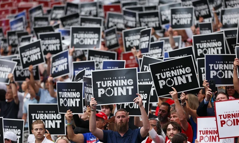GLENDALE, ARIZONA - SEPTEMBER 21: Attendees hold up Turning Point USA signs at the memorial service for political activist Charlie Kirk at State Farm Stadium on September 21, 2025 in Glendale, Arizona. Kirk, the CEO and co-founder of Turning Point USA, was shot and killed on September 10th while speaking at an event during his "American Comeback Tour" at Utah Valley University. (Photo by Eric Thayer/Getty Images)