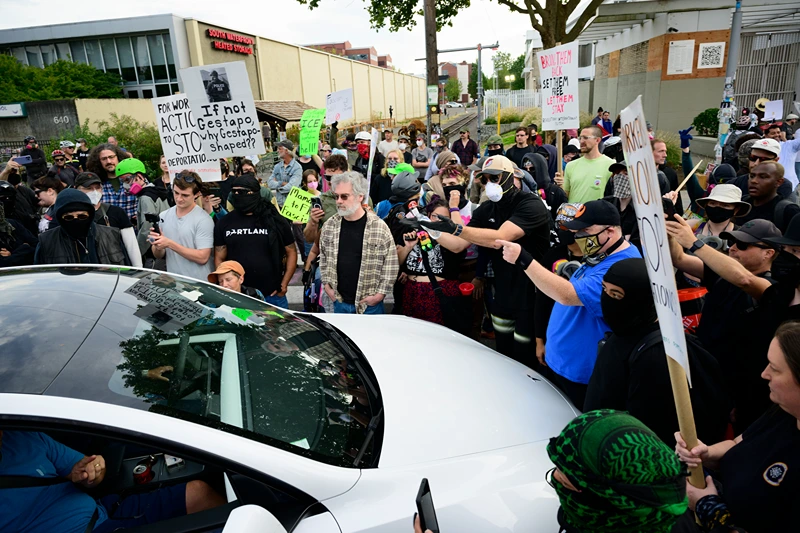 PORTLAND, OREGON - SEPTEMBER 28: Protesters engage a vehicle that drove into the crowd outside of the U.S. Immigration and Customs Enforcement building on September 28, 2025 in Portland, Oregon. In a Truth Social post on September 27th, President Trump authorized the deployment of military troops to "protect War ravaged Portland, and any of our ICE Facilities under siege from attack by Antifa, and other domestic terrorists." (Photo by Mathieu Lewis-Rolland/Getty Images)