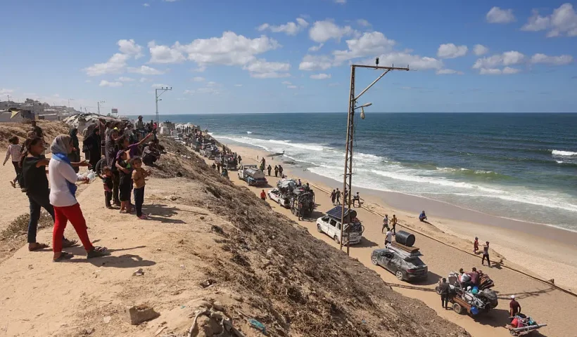 Palestinians carrying belongings arrive on a coastal path northwest of Nuseirat refugee camp as they are displaced southward from Wadi Gaza following an Israeli announcement of closing Al-Rashid road towards the north of the besieged Gaza Strip on October 1, 2025. Israel's defence minister issued a final warning for Gaza City residents to flee south on October 1, as the Palestinian Hamas movement weighed the latest US plan to end nearly two years of war in the Palestinian territory. (Photo by Bashar TALEB / AFP) (Photo by BASHAR TALEB/AFP via Getty Images)