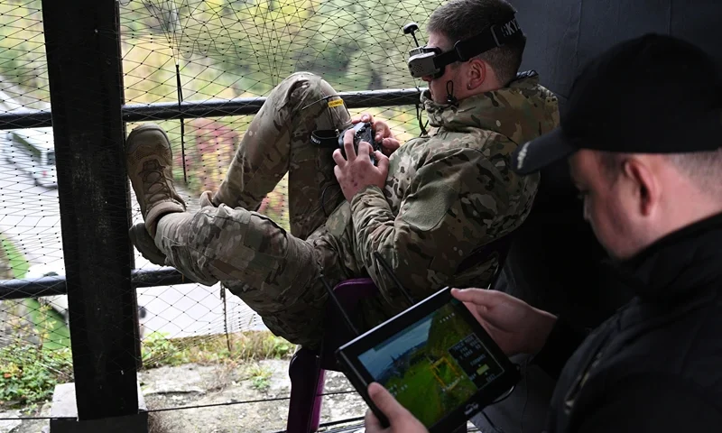 A Ukrainian serviceman (L) operates a drone during the 'Wild Drones' drone racing competition, which simulates combat conditions, in Kamianets-Podilskyi, Khmelnytsky region on October 5, 2025, amid the Russian invasion of Ukraine. (Photo by YURIY DYACHYSHYN / AFP) (Photo by YURIY DYACHYSHYN/AFP via Getty Images)