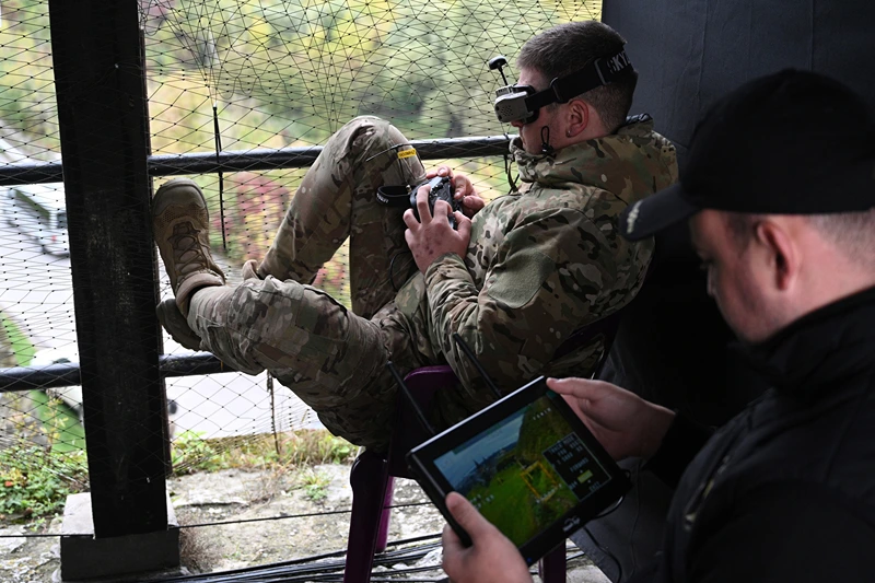 A Ukrainian serviceman (L) operates a drone during the 'Wild Drones' drone racing competition, which simulates combat conditions, in Kamianets-Podilskyi, Khmelnytsky region on October 5, 2025, amid the Russian invasion of Ukraine. (Photo by YURIY DYACHYSHYN / AFP) (Photo by YURIY DYACHYSHYN/AFP via Getty Images)