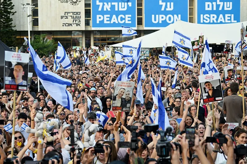 TEL AVIV, ISRAEL - OCTOBER 13: People gather to watch the hostage release live stream at Hostages Square on October 13, 2025 in Tel Aviv, Israel. The ceasefire deal between Israel and Hamas has brought an end to the two years of war that followed the attacks of Oct. 7, 2023. A condition of the deal was the immediate return of 48 hostages held in Gaza, around 20 of whom were believed to be alive. (Photo by Alexi J. Rosenfeld/Getty Images)