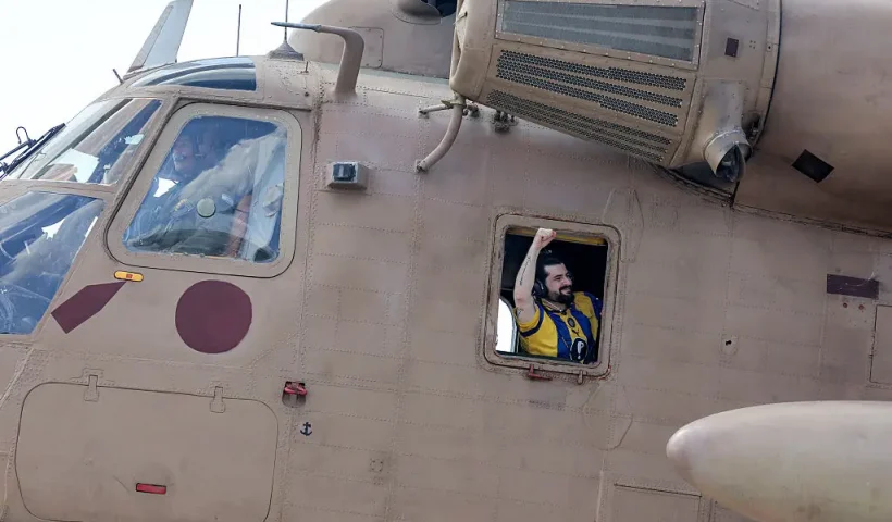 TOPSHOT - Ziv Berman, one of the released Israeli hostages formerly held captive in Gaza since the 2023 October 7 attacks by Palestinian militants, gestures from the window of an Israeli CH-53 Sea Stallion military helicopter at Sheba Tel-HaShomer Medical Centre in Ramat Gan on October 13, 2025. (Photo by Ahmad GHARABLI / AFP) (Photo by AHMAD GHARABLI/AFP via Getty Images)