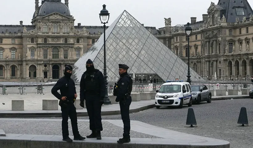 French police officers stand in front of the Louvre Museum after robbery, in Paris on October 19, 2025. Robbers broke in to the Louvre and fled with jewellery on October 19, 2025 morning, a source close to the case said, adding that its value was still being evaluated. A police source said an unknown number of thieves arrived on a scooter armed with small chainsaws and used a goods lift to reach the room they were targeting. (Photo by Dimitar DILKOFF / AFP) / -- IMAGE RESTRICTED TO EDITORIAL USE - STRICTLY NO COMMERCIAL USE -- (Photo by DIMITAR DILKOFF/AFP via Getty Images)