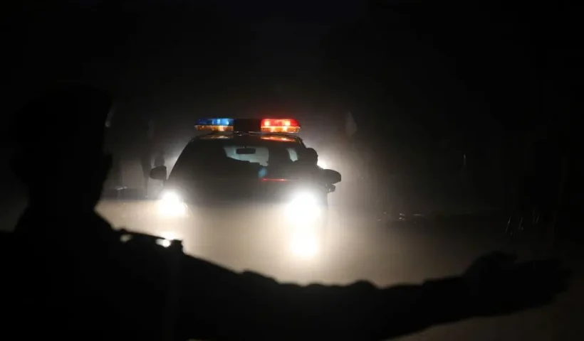 A police officer gestures as a police car runs on a street at night on November 28, 2017 in Ouagadougou. (Photo by LUDOVIC MARIN / AFP) (Photo by LUDOVIC MARIN/AFP via Getty Images)