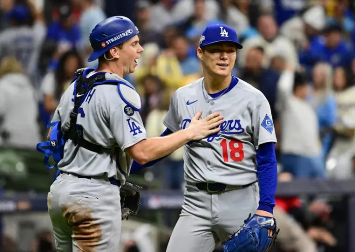 Los Angeles Dodgers catcher Will Smith (16) and pitcher Yoshinobu Yamamoto (18) celebrate after defeating the Milwaukee Brewers in game two of the NLCS round for the 2025 MLB playoffs at American Family Field. Mandatory Credit: Benny Sieu-Imagn Images