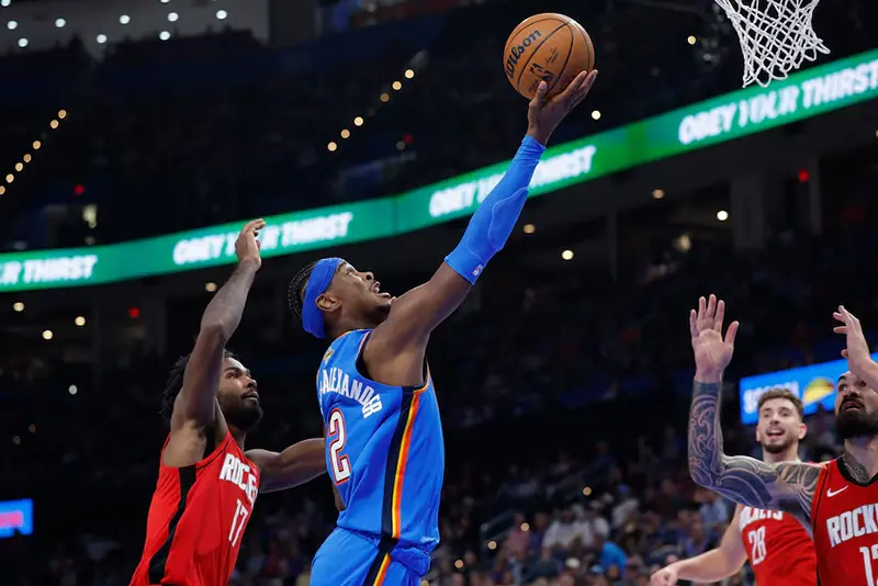 Oklahoma City Thunder guard Shai Gilgeous-Alexander (2) goes up for a basket between Houston Rockets forward Tari Eason (17) and center Steven Adams (12) during the first half at Paycom Center. Mandatory Credit: Alonzo Adams-Imagn Images