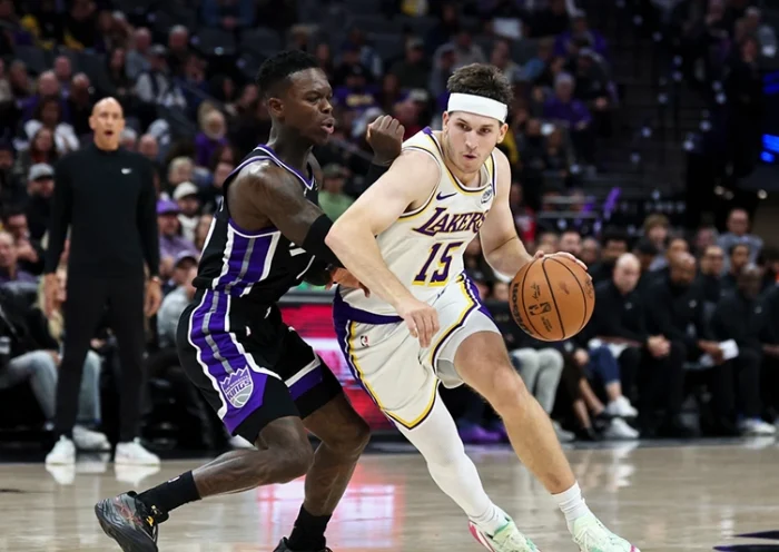 Los Angeles Lakers guard Austin Reaves (15) drives to the basket with Sacramento Kings guard Dennis Schröder, left, defending during the second half of an NBA basketball game Sunday, Oct. 26, 2025, in Sacramento, Calif. (AP Photo/Sara Nevis)