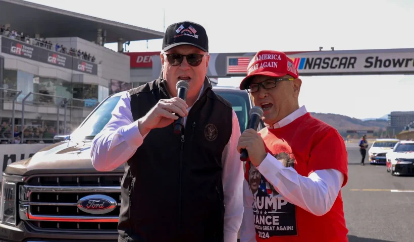 U.S. Ambassador to Japan George Glass and Akio Toyoda hold microphones at the Fuji Speedway in Oyama, Shizuoma, Japan on Sunday, November 16, 2025. (George Glass, X)