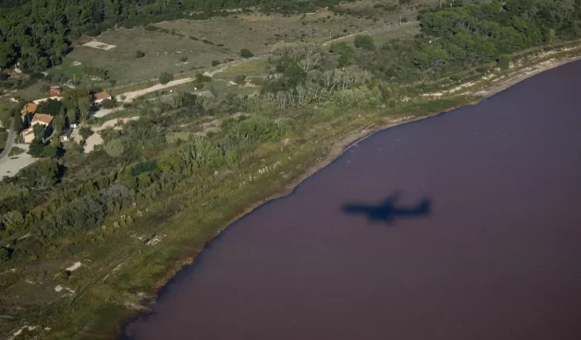This photograph shows an aerial view of a shadow of a plane flying over the pink Lavalduc Lake in Istres, southeastern France, on October 4, 2024. (Photo by CLEMENT MAHOUDEAU / AFP) (Photo by CLEMENT MAHOUDEAU/AFP via Getty Images)