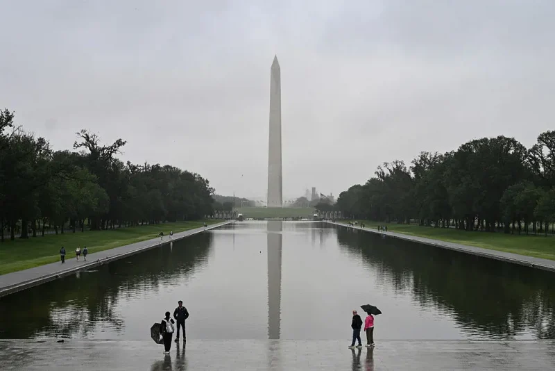 People stand near the Lincoln Memorial Reflecting Pool after a rainstorm in Washington DC, on May 28, 2025. (Photo by ALEX WROBLEWSKI / AFP) (Photo by ALEX WROBLEWSKI/AFP via Getty Images)