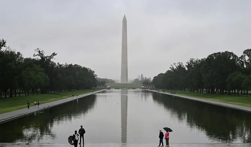 People stand near the Lincoln Memorial Reflecting Pool after a rainstorm in Washington DC, on May 28, 2025. (Photo by ALEX WROBLEWSKI / AFP) (Photo by ALEX WROBLEWSKI/AFP via Getty Images)