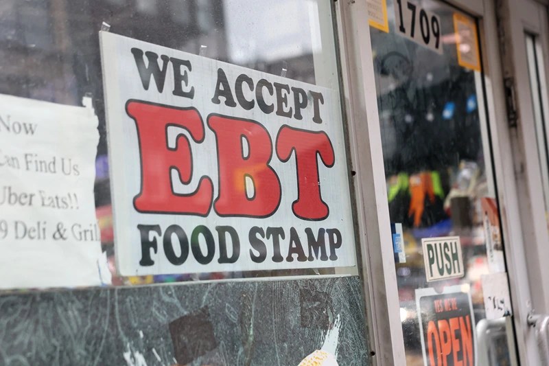 NEW YORK, NEW YORK - OCTOBER 30: An EBT sign is displayed on the window of a grocery store on October 30, 2025 in the Flatbush neighborhood of the Brooklyn borough in New York City. Supplemental Nutrition Assistance Program (SNAP) benefits and other assistance are set to stop on November 1st amid a federal government shutdown that has been going on for 29 days and is the second-longest shutdown in the nation's history. New York Gov. Kathy Hochul declared a state of emergency for extra emergency funds and personnel to be deployed, as SNAP payments will be suspended. About 42 million Americans are expected to lose access to their benefits. (Photo by Michael M. Santiago/Getty Images)