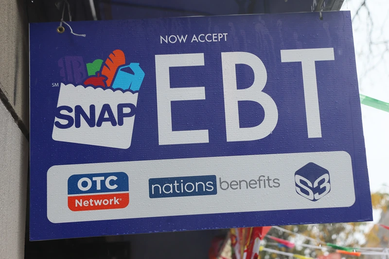 NEW YORK, NEW YORK - OCTOBER 30: An EBT sign is displayed on the window of a grocery store on October 30, 2025 in the Flatbush neighborhood of the Brooklyn borough in New York City. Supplemental Nutrition Assistance Program (SNAP) benefits and other assistance are set to stop on November 1st amid a federal government shutdown that has been going on for 29 days and is the second-longest shutdown in the nation's history. New York Gov. Kathy Hochul declared a state of emergency for extra emergency funds and personnel to be deployed, as SNAP payments will be suspended. About 42 million Americans are expected to lose access to their benefits. (Photo by Michael M. Santiago/Getty Images)