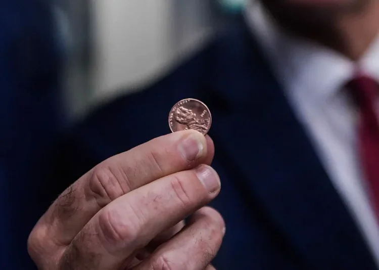 PHILADELPHIA, PENNSYLVANIA - NOVEMBER 12: Treasurer of the United States Brandon Beach holds the last penny stamped at the US Mint on November 12, 2025 in Philadelphia, Pennsylvania. Beach pressed the final pennies at an event held at the facility. The pennies pressed bear a special 'Omega' and will not be put in circulation, but will be auctioned off. (Photo by Matthew Hatcher/Getty Images)
