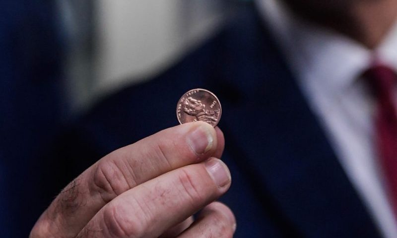 PHILADELPHIA, PENNSYLVANIA - NOVEMBER 12: Treasurer of the United States Brandon Beach holds the last penny stamped at the US Mint on November 12, 2025 in Philadelphia, Pennsylvania. Beach pressed the final pennies at an event held at the facility. The pennies pressed bear a special 'Omega' and will not be put in circulation, but will be auctioned off. (Photo by Matthew Hatcher/Getty Images)