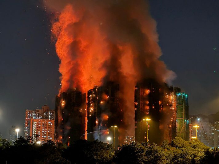 TOPSHOT - Thick smoke and flames rise as a major fire engulfs several apartment blocks at the Wang Fuk Court residential estate in Hong Kong's Tai Po district on November 26, 2025. At least four people were killed when a fire engulfed several high-rise blocks in a Hong Kong residential estate on November 26, the government said, with media reporting that some residents were trapped inside. (Photo by Yan ZHAO / AFP via Getty Images)