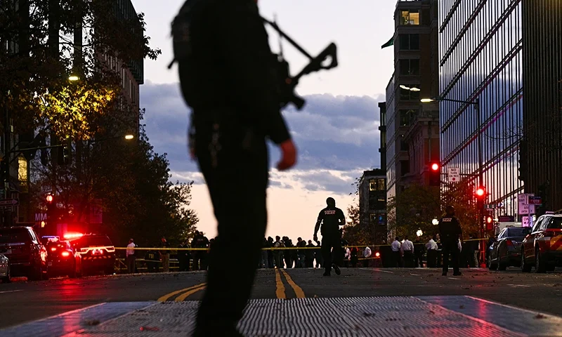 A police officer secures the area as law-enforcement officials visit the crime scene of a shooting in downtown Washington, DC, on November 26, 2025. On November 26, Police in Washington said they had detained a suspect after two National Guard troops were shot blocks away from the White House. FBI director Kash Patel said the two Guard troops are in critical condition. (Photo by Brendan SMIALOWSKI / AFP via Getty Images)