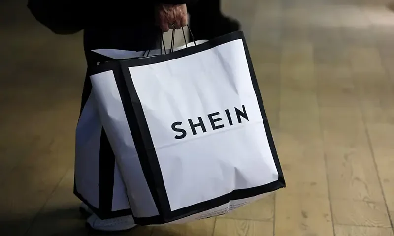A customer holds shopping bags with a Shein logo in the first physical space of Chinese online fast-fashion retailer Shein on the day of its opening inside the Le BHV Marais department store, the Bazar de l'Hotel de Ville, in Paris, France, November 5, 2025. REUTERS/Sarah Meyssonnier