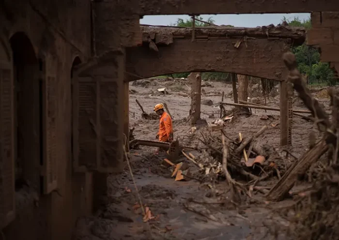 A rescue worker walks between destroyed houses after a dam burst in the town of Bento Rodrigues, Minas Gerais state, Brazil, Nov. 8, 2015. (AP Photo/Felipe Dana, File)
