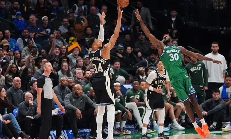 Milwaukee Bucks forward Giannis Antetokounmpo (34) shoots a three-pointer against Dallas Mavericks center Moussa Cisse (30) during the second half of an NBA basketball game in Dallas, Monday, Nov. 10, 2025. (AP Photo/LM Otero)