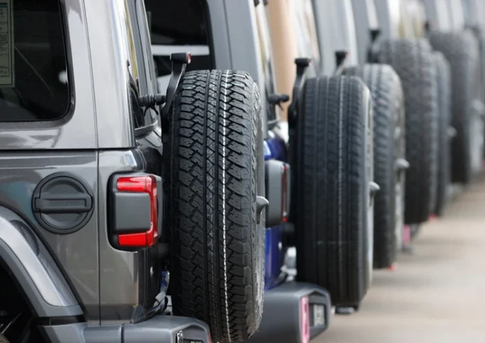 Spare tires are seen on a long row of unsold 2020 Wranglers sit at a Jeep dealership in Englewood, Colo., on April 26, 2020. (AP Photo/David Zalubowski, File)