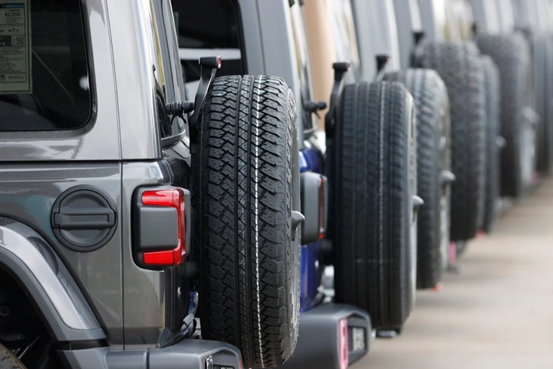 Spare tires are seen on a long row of unsold 2020 Wranglers sit at a Jeep dealership in Englewood, Colo., on April 26, 2020. (AP Photo/David Zalubowski, File)