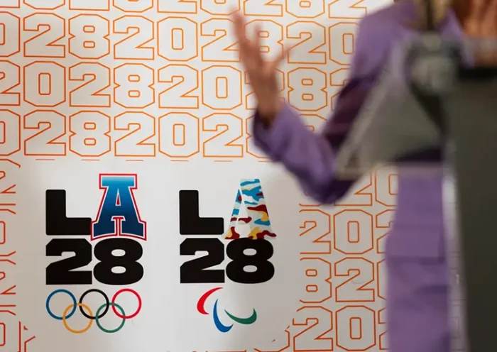 LA28 logos decorate a backdrop a reception to celebrate the upcoming 2028 Olympic Games, to be held in Los Angeles, Saturday, July 27, 2024, in Paris. (AP Photo/David Goldman, File)