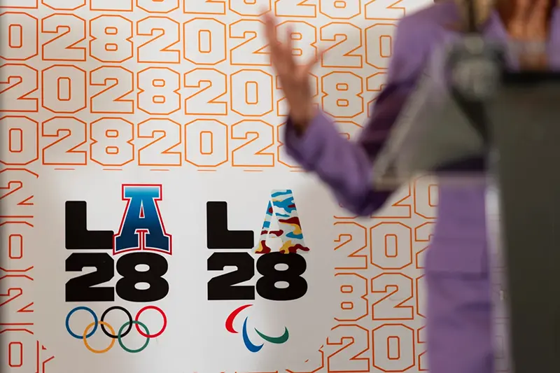 LA28 logos decorate a backdrop a reception to celebrate the upcoming 2028 Olympic Games, to be held in Los Angeles, Saturday, July 27, 2024, in Paris. (AP Photo/David Goldman, File)