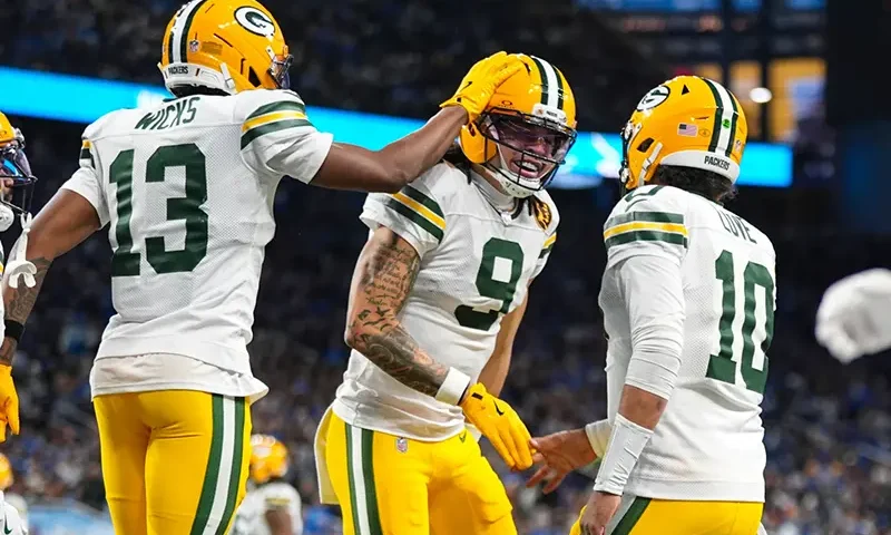 Green Bay Packers wide receiver Christian Watson (9) celebrates a touchdown with wide receiver Dontayvion Wicks (13) and quarterback Jordan Love (10) against the Detroit Lions during the second half an NFL football game in Detroit, Thursday, Nov. 27, 2025. (AP Photo/Ryan Sun)