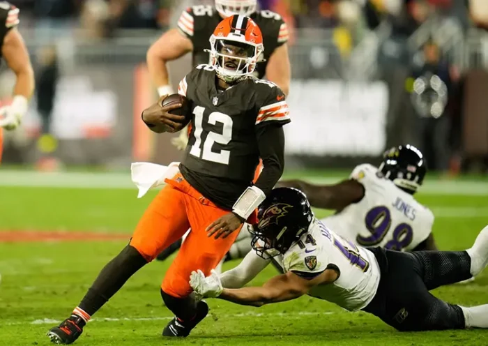 Cleveland Browns quarterback Shedeur Sanders (12) is stopped by Baltimore Ravens safety Kyle Hamilton (14) in the second half of an NFL football game in Cleveland, Sunday, Nov. 16, 2025. (AP Photo/Sue Ogrocki)