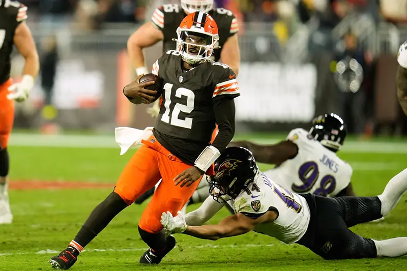 Cleveland Browns quarterback Shedeur Sanders (12) is stopped by Baltimore Ravens safety Kyle Hamilton (14) in the second half of an NFL football game in Cleveland, Sunday, Nov. 16, 2025. (AP Photo/Sue Ogrocki)
