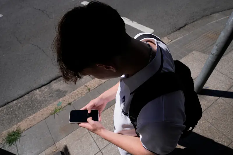 A teenage boy uses his phone in Sydney, Nov. 8, 2024. (AP Photo/Rick Rycroft, File)