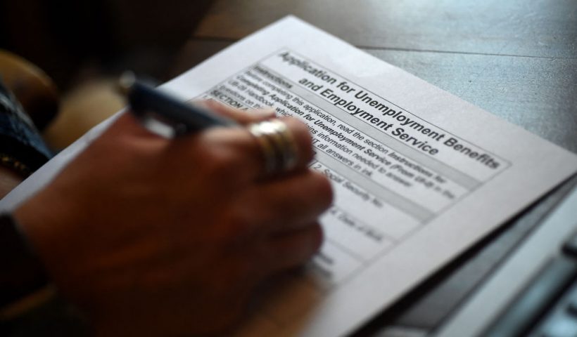 In this photo illustration, a person files an application for unemployment benefits on April 16, 2020, in Arlington, Virginia. The government reported Thursday that another 5.2 million US workers filed for unemployment benefits, taking the four-week total to 22 million, a staggering figure in a downturn that economists say presents the country with its most severe outlook since the Great Depression of the 1930s. (Photo by Olivier DOULIERY / AFP) (Photo by OLIVIER DOULIERY/AFP via Getty Images)
