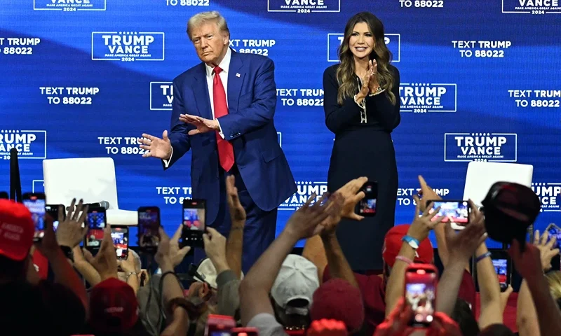Former US President and Republican presidential candidate Donald Trump, with moderator and South Dakota Governor Kristi Noem (R), arrives for a town hall at the Greater Philadelphia Expo Center and Fairgrounds in Oaks, Pennsylvania, on October 14, 2024. (Photo by Jim WATSON / AFP) (Photo by JIM WATSON/AFP via Getty Images)