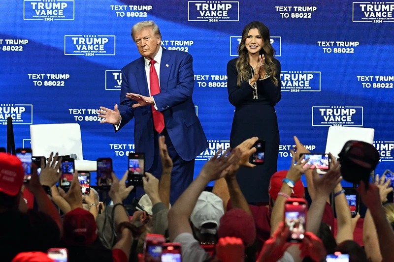 Former US President and Republican presidential candidate Donald Trump, with moderator and South Dakota Governor Kristi Noem (R), arrives for a town hall at the Greater Philadelphia Expo Center and Fairgrounds in Oaks, Pennsylvania, on October 14, 2024. (Photo by Jim WATSON / AFP) (Photo by JIM WATSON/AFP via Getty Images)